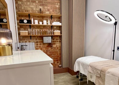 Relaxing treatment room at Facials by MS in Sutton, England, GB, featuring cozy bed and ambient lighting.