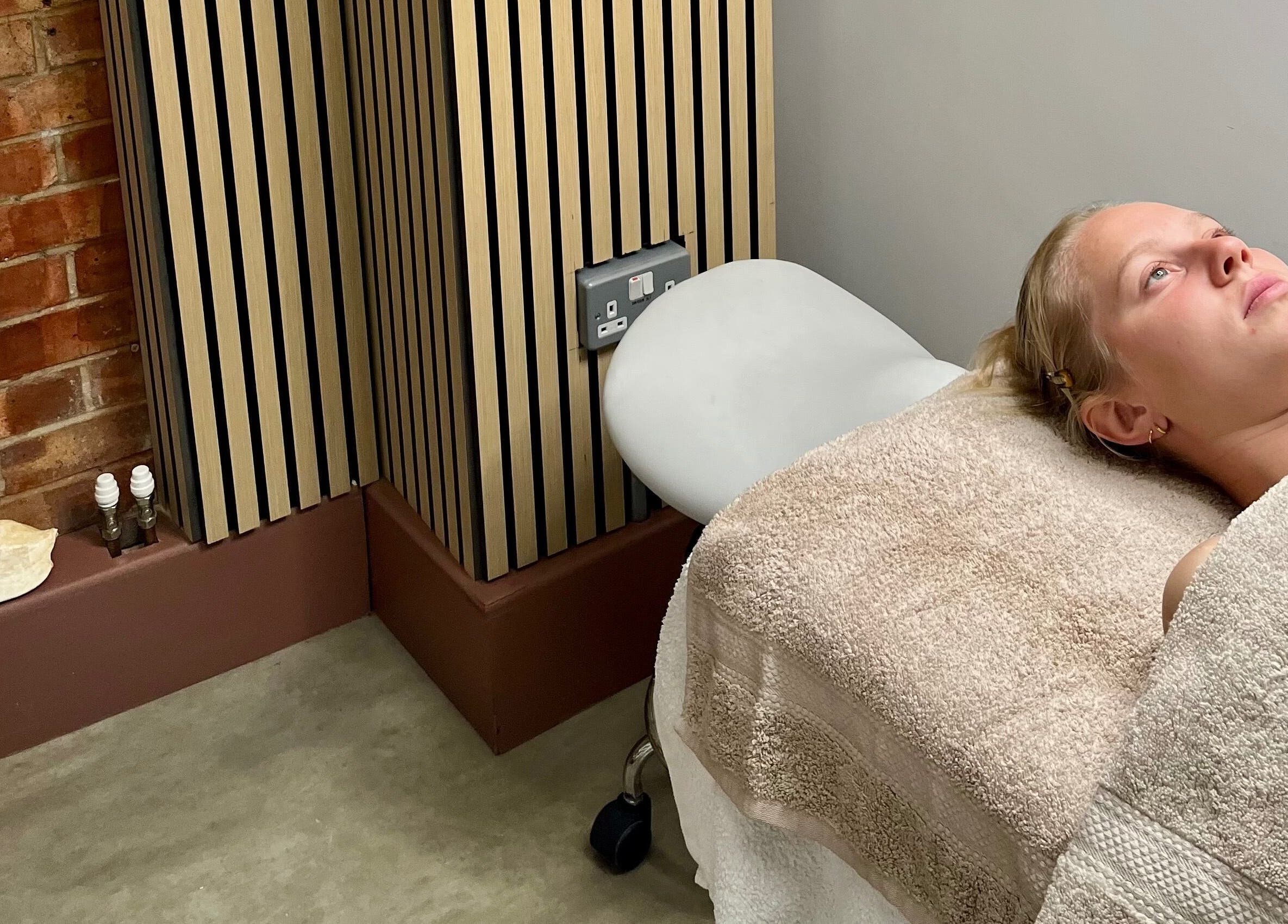 A client relaxing on a treatment bed at Facials by MS, Sutton, England, GB.