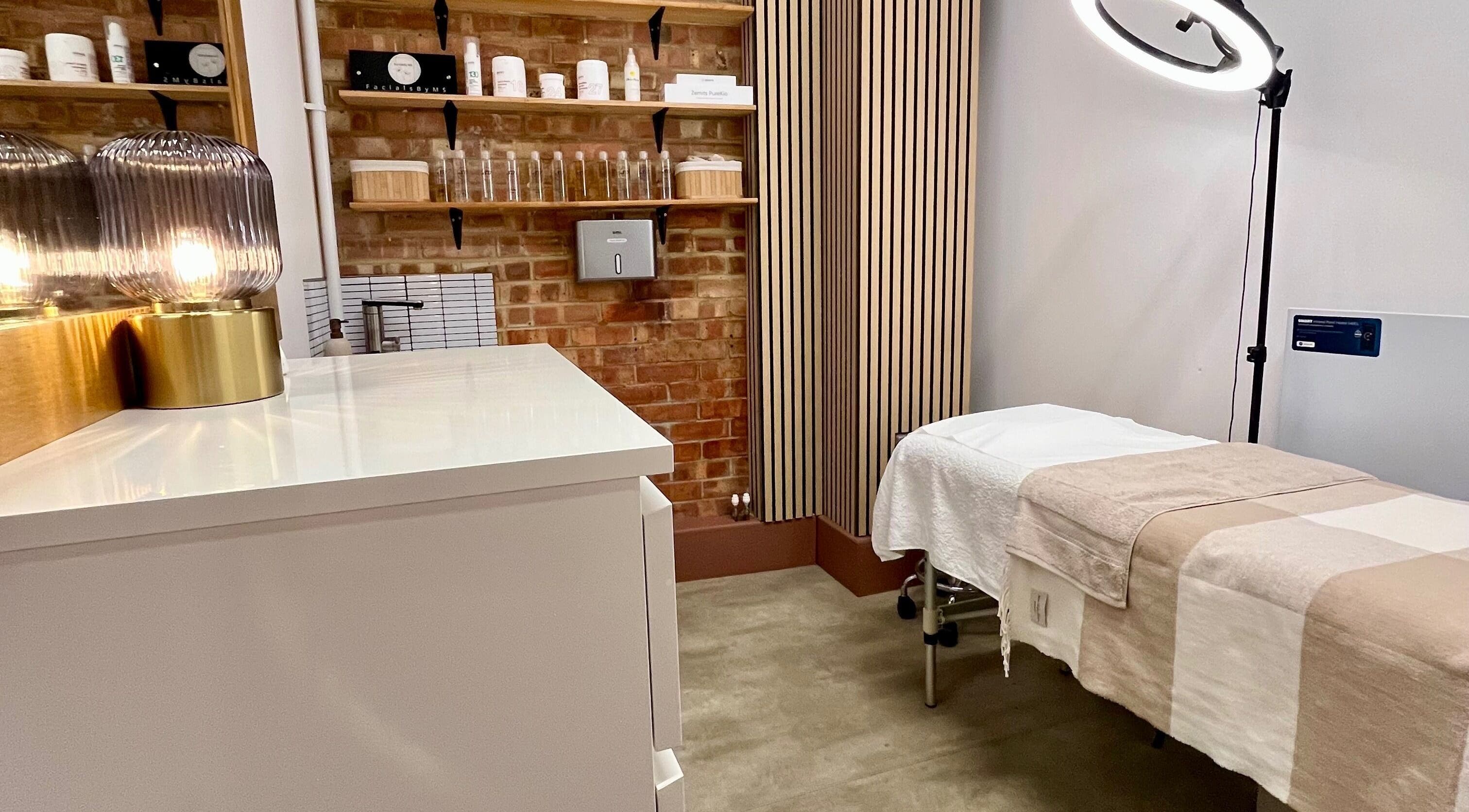 Elegant treatment room at Facials by MS, Sutton, England, GB, featuring a cozy massage table and warm lighting.