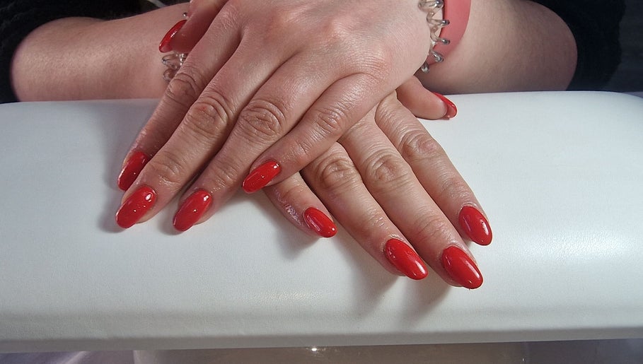 Manicured hands with red nails at Lisa Luxe Treatments, Birmingham, England, GB.