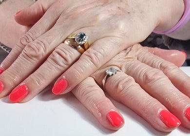 Manicured hands adorned with coral nails at Lisa Luxe Treatments, Birmingham, England, GB.