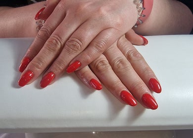 Manicured hands with red nails at Lisa Luxe Treatments, Blackwell, England, GB.