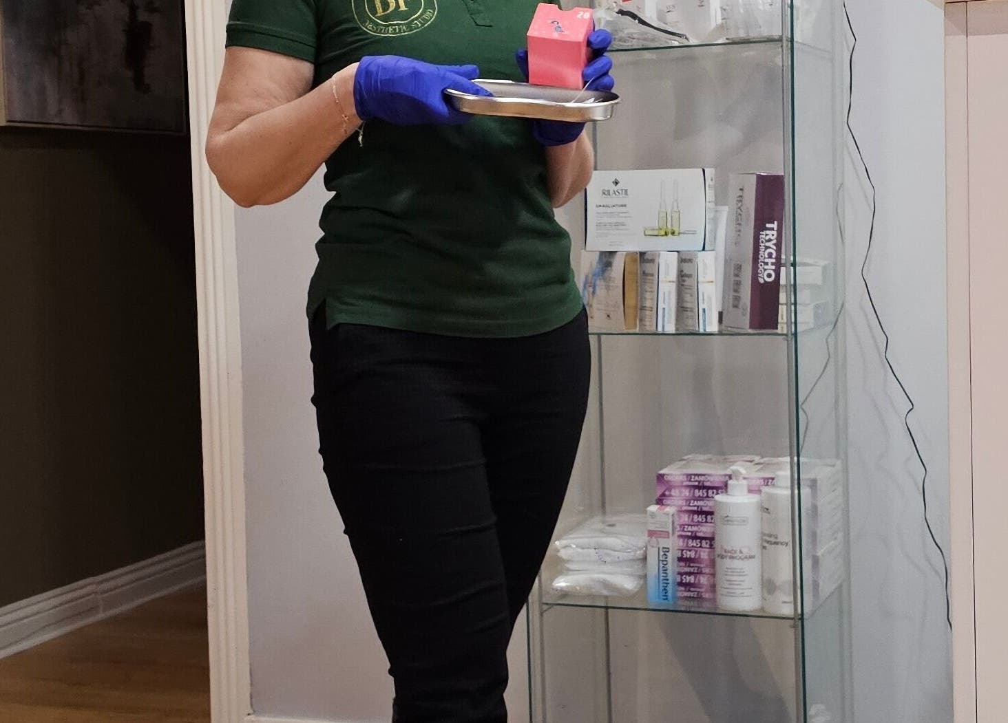 Staff member at Beauty Factory, Gaillimh, Galway, IE prepares products on a tray beside a display shelf.