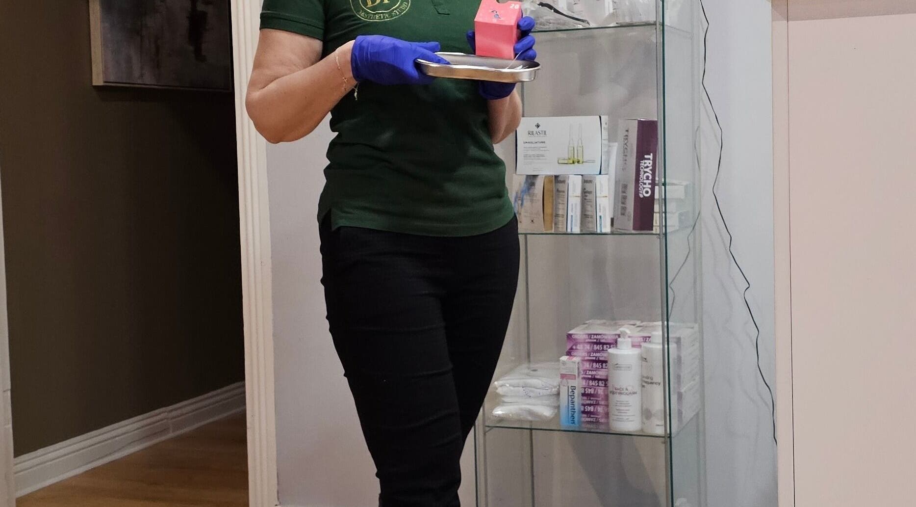 Staff member at Beauty Factory, Gaillimh, Galway, IE prepares products on a tray beside a display shelf.