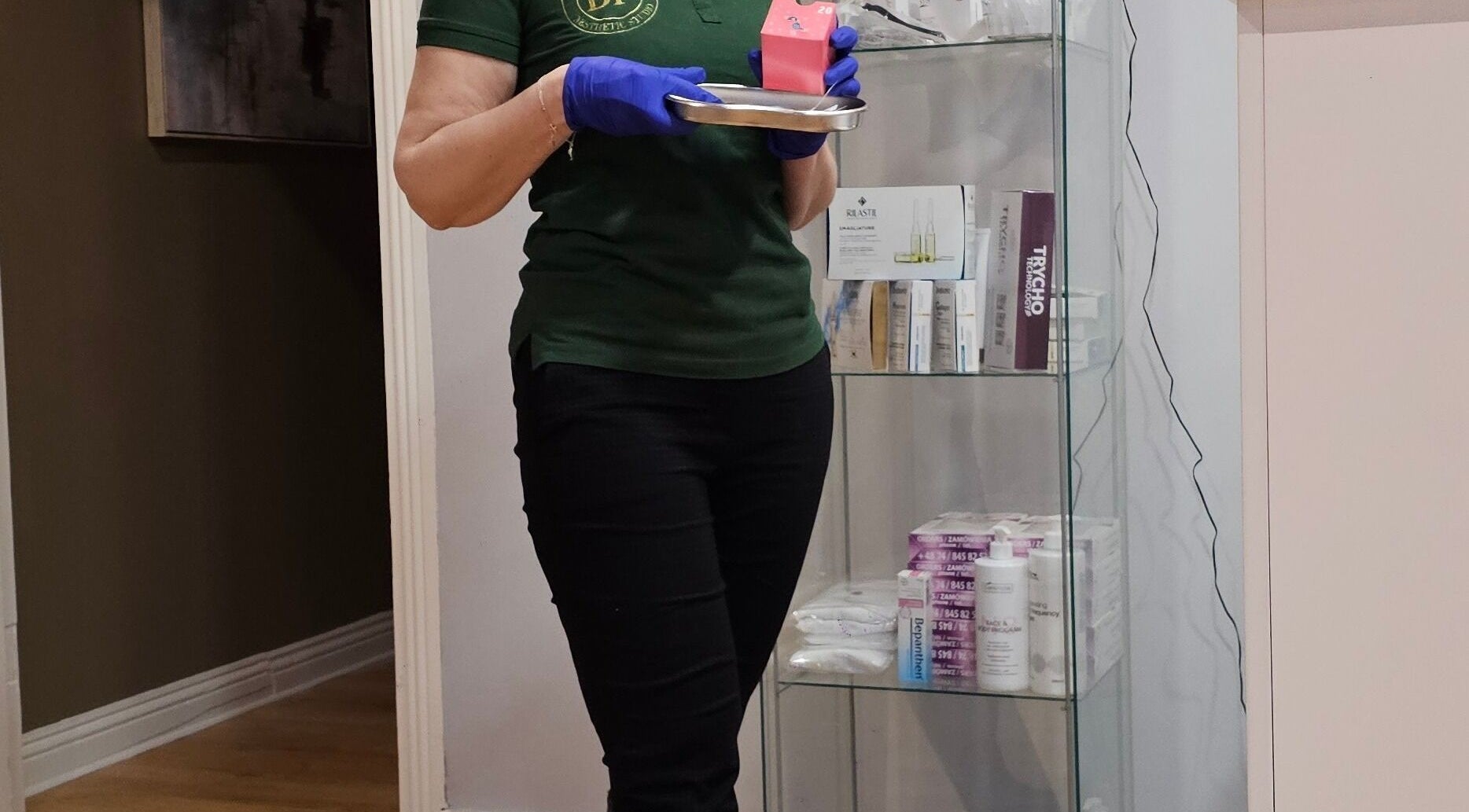 Staff member at Beauty Factory, Gaillimh, Galway, IE prepares products on a tray beside a display shelf.