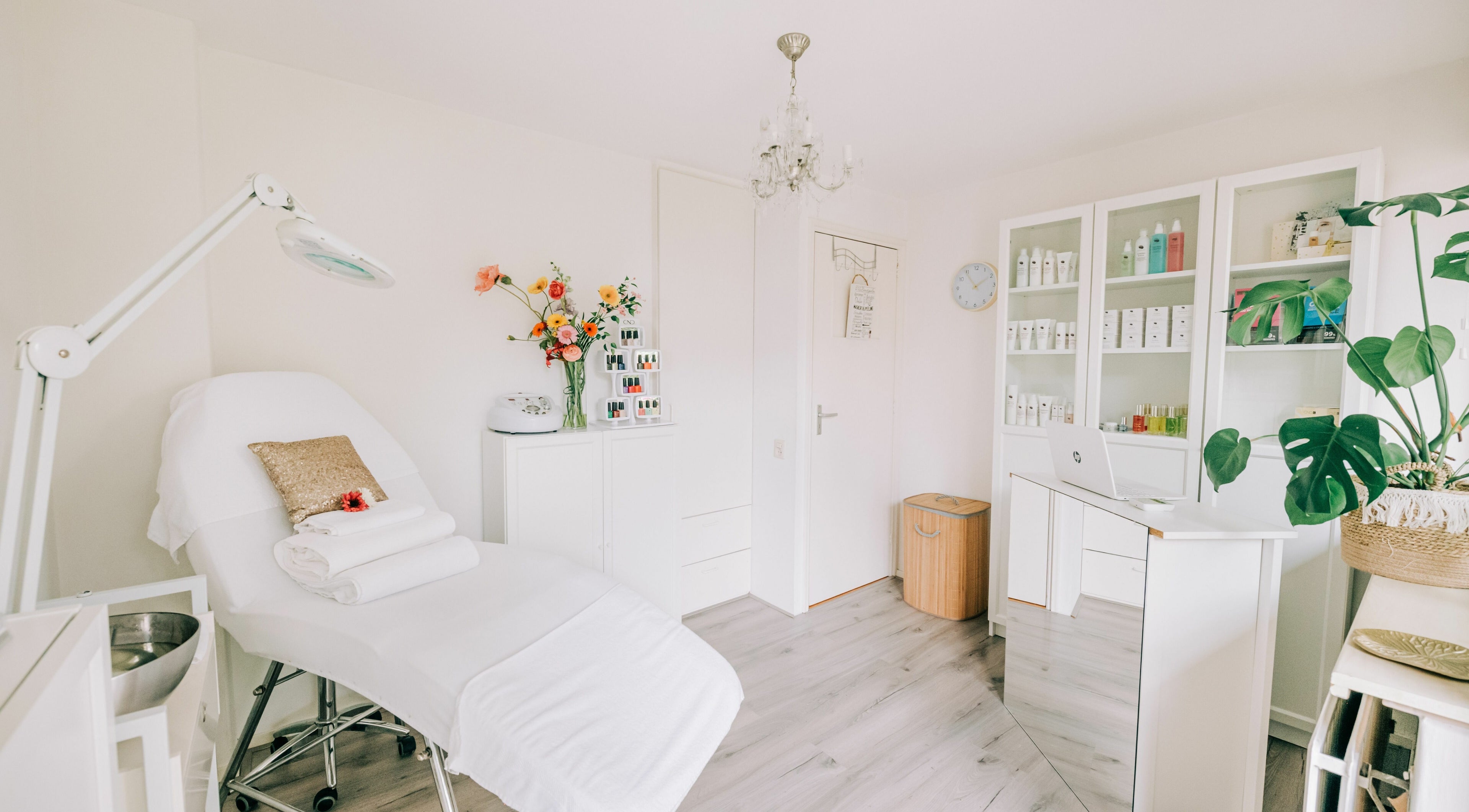 Binnenkant van Corine's Beauty Salon in Bodegraven, Zuid-Holland, NL, met moderne behandelkamer en bloemen.