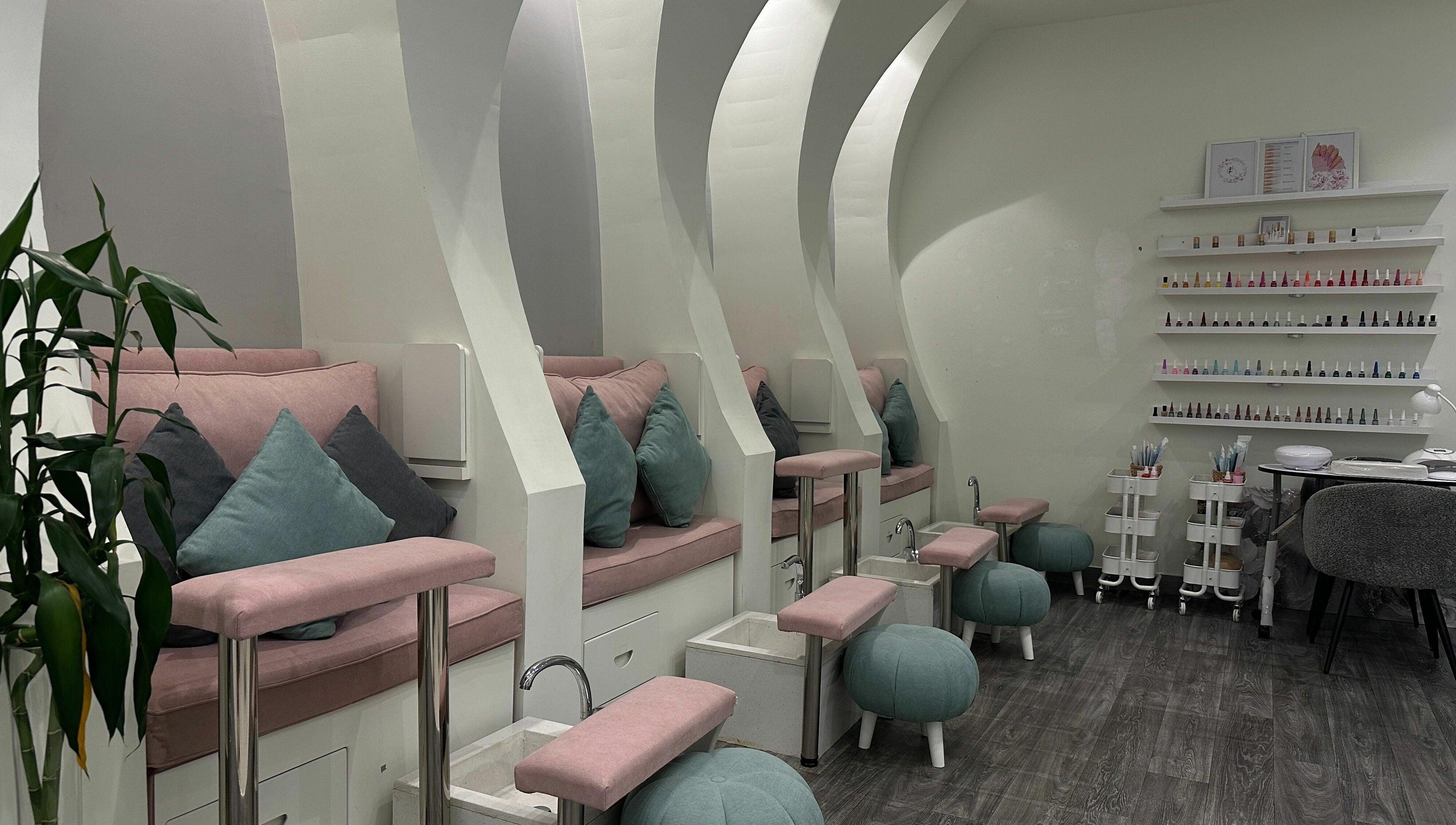 Cozy pedicure seating at Aime Toi, Riyadh, Riyadh Province, SA with plush cushions and nail polish display.