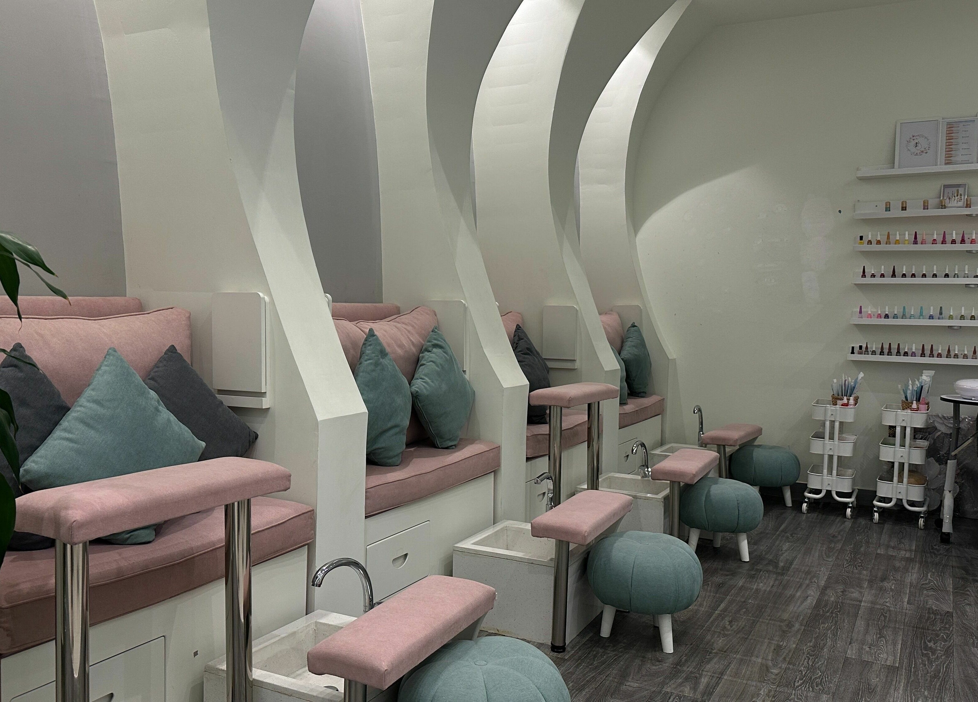 Cozy pedicure seating at Aime Toi, Riyadh, Riyadh Province, SA with plush cushions and nail polish display.