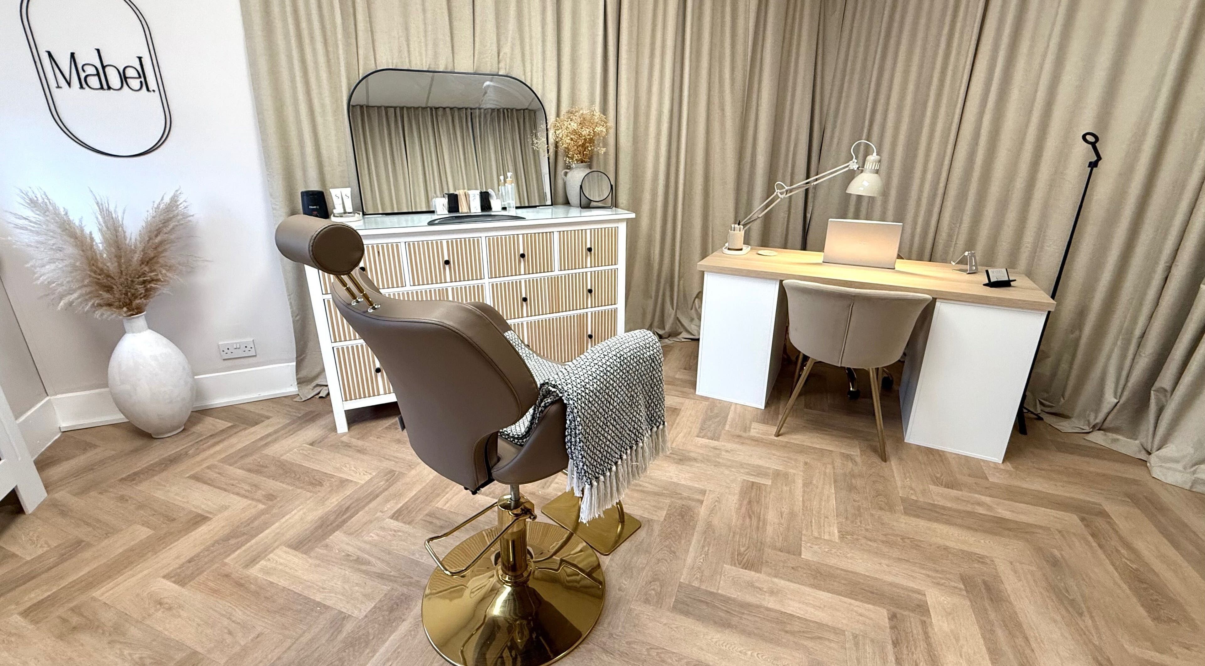 Chic salon interior at Mabel Studio, Blantyre, Scotland, GB, featuring a stylish chair and modern workspace.