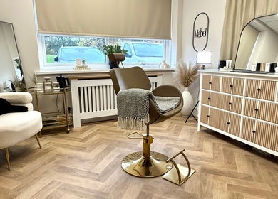 A cozy seating area at Mabel Studio in Blantyre, Scotland, GB featuring stylish furnishings and a mirror.