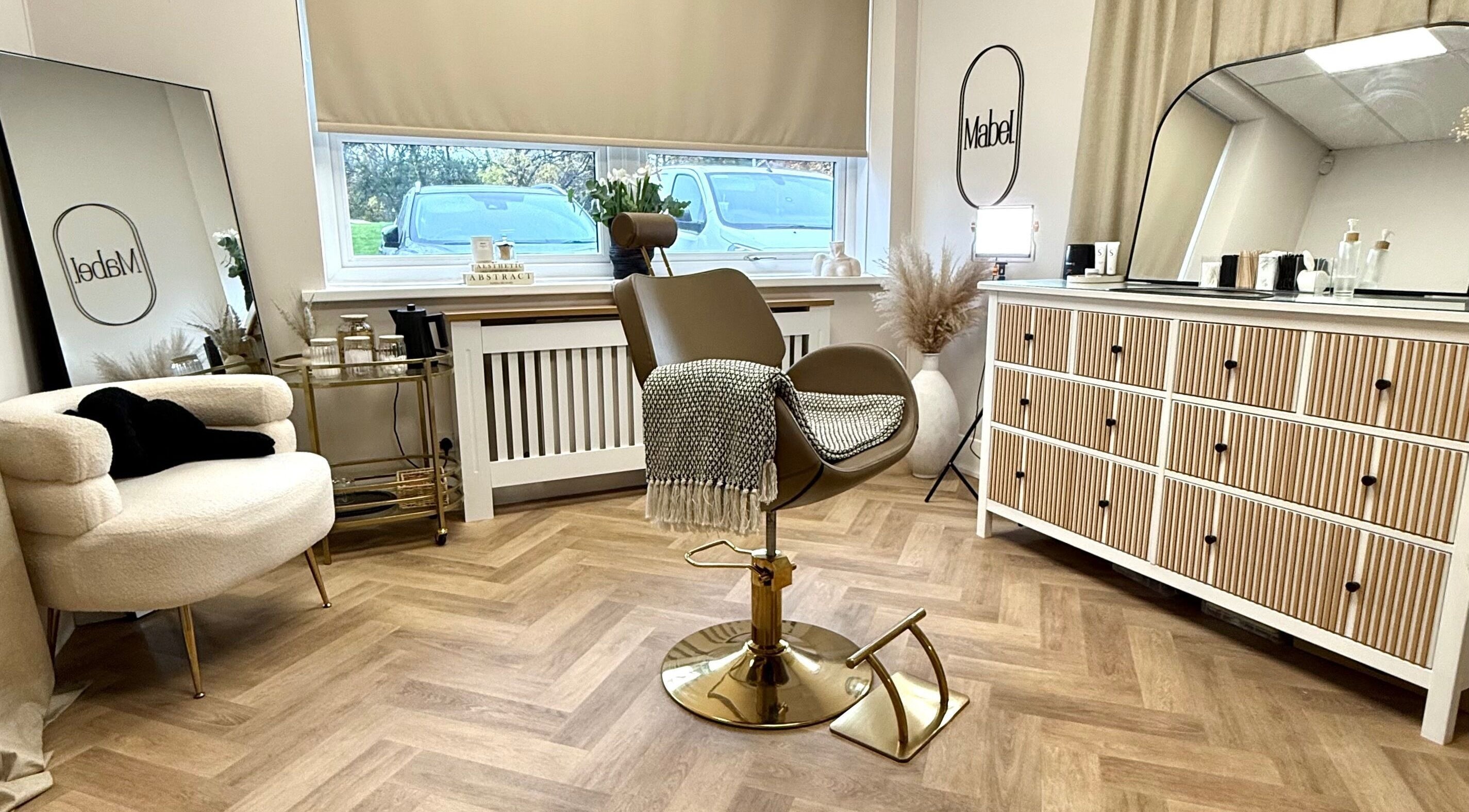 A cozy seating area at Mabel Studio in Blantyre, Scotland, GB featuring stylish furnishings and a mirror.