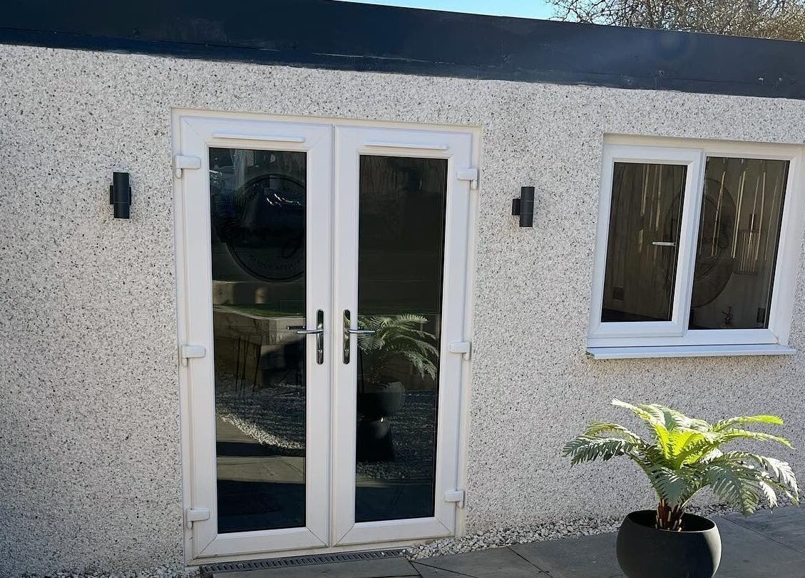 Front view of Mabel Studio in Blantyre, Scotland, GB with white door and potted plant.