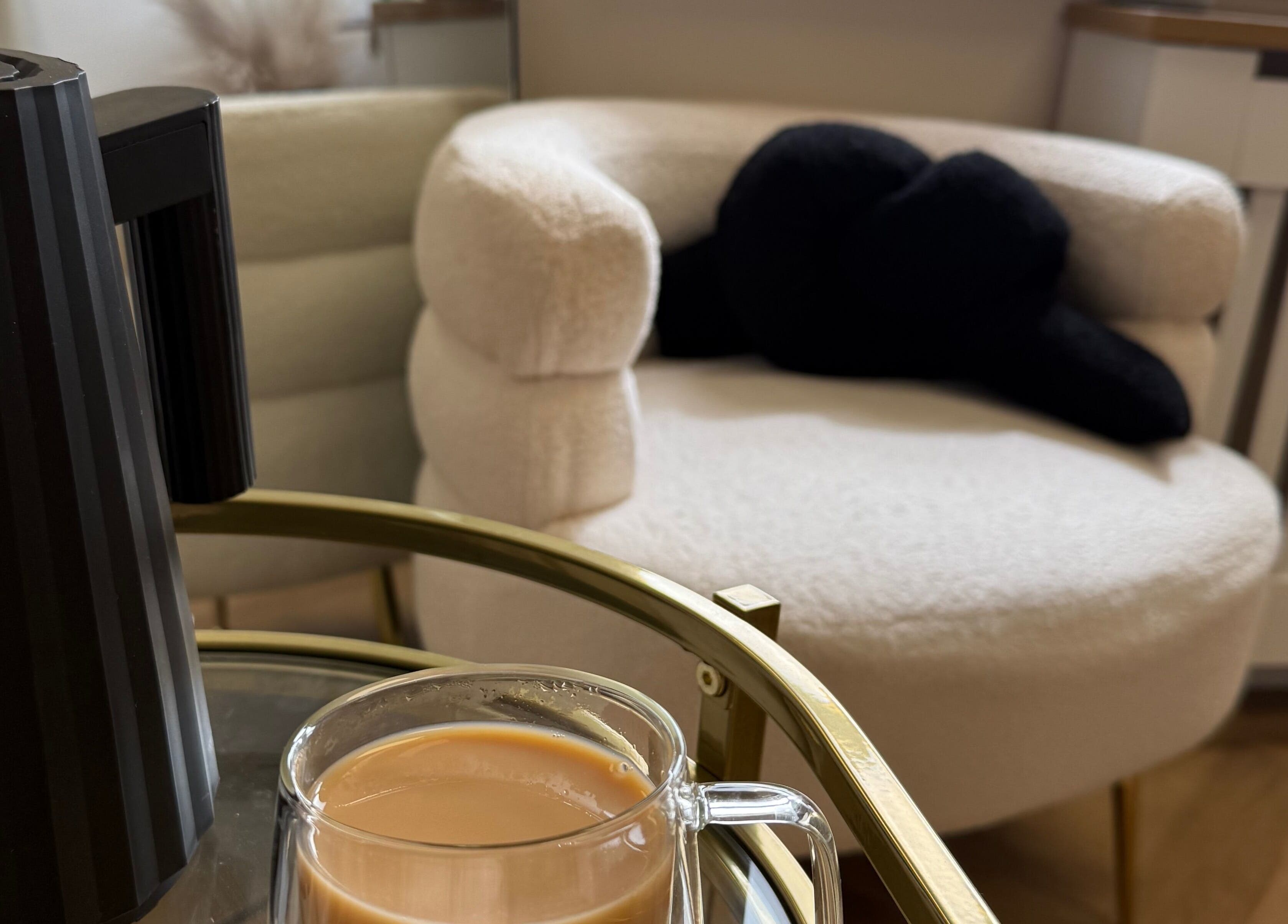 Relaxing seating area with a plush chair at Mabel Studio, Blantyre, Scotland, GB with tea and elegant decor.