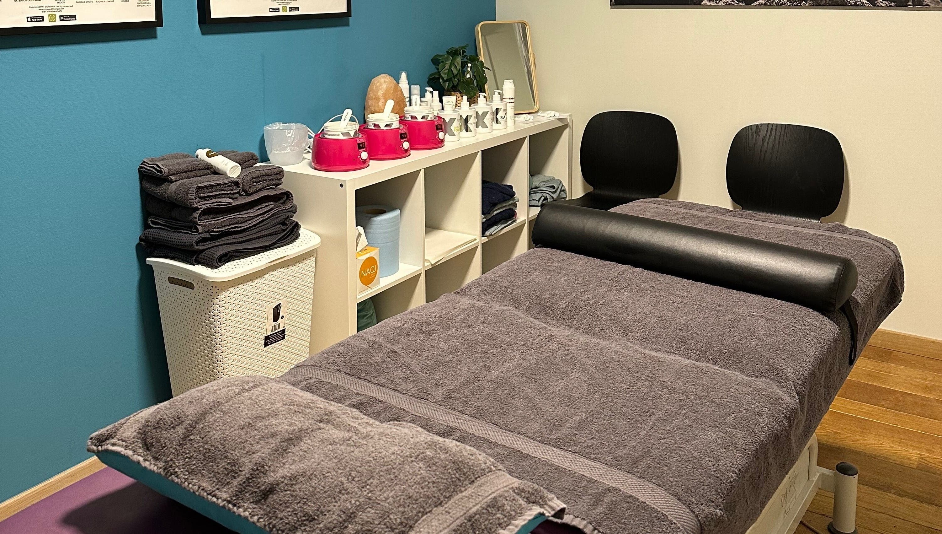 Gezellige behandelkamer bij BodyCare Dimitri in Sint-niklaas, Vlaams Gewest, BE met zachte handdoeken en huidverzorging.