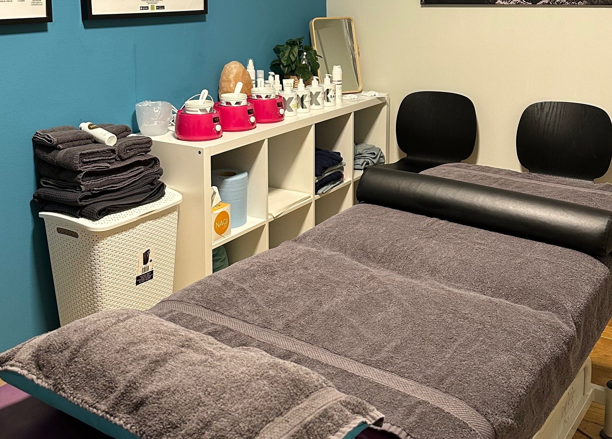 Gezellige behandelkamer bij BodyCare Dimitri in Sint-niklaas, Vlaams Gewest, BE met zachte handdoeken en huidverzorging.