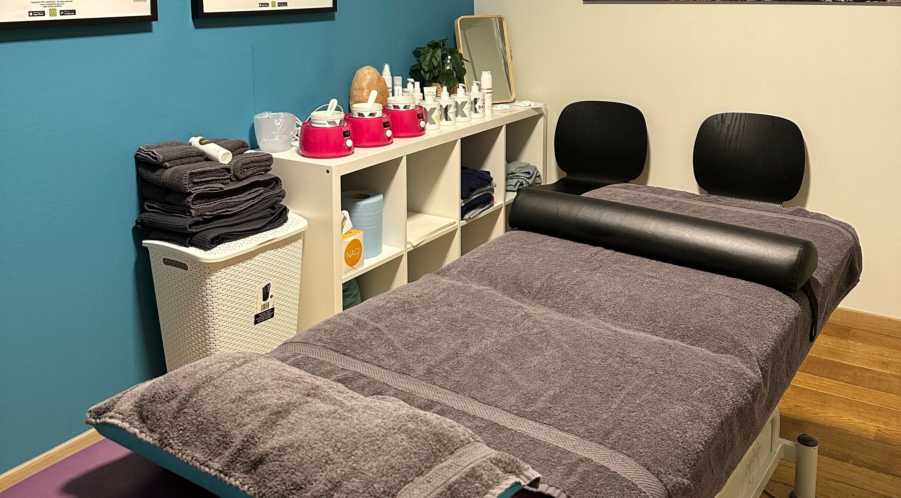 Gezellige behandelkamer bij BodyCare Dimitri in Sint-niklaas, Vlaams Gewest, BE met zachte handdoeken en huidverzorging.