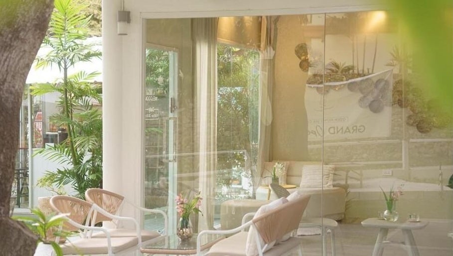 Relaxing seating area at Ozen Home Spa Cafe, Pattaya, Chon Buri, TH, with greenery and soft lighting.