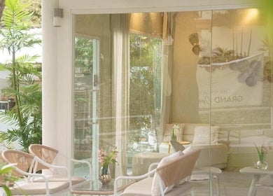Relaxing seating area at Ozen Home Spa Cafe, Pattaya, Chon Buri, TH, with greenery and soft lighting.