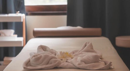 Massage table with towels and flower at Ozen Home Spa Cafe, Pattaya, Chon Buri, TH, offering a serene ambiance.