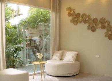 Relaxing lounge area at Ozen Home Spa Cafe in Pattaya, Chon Buri, TH with plush seating and nature views.