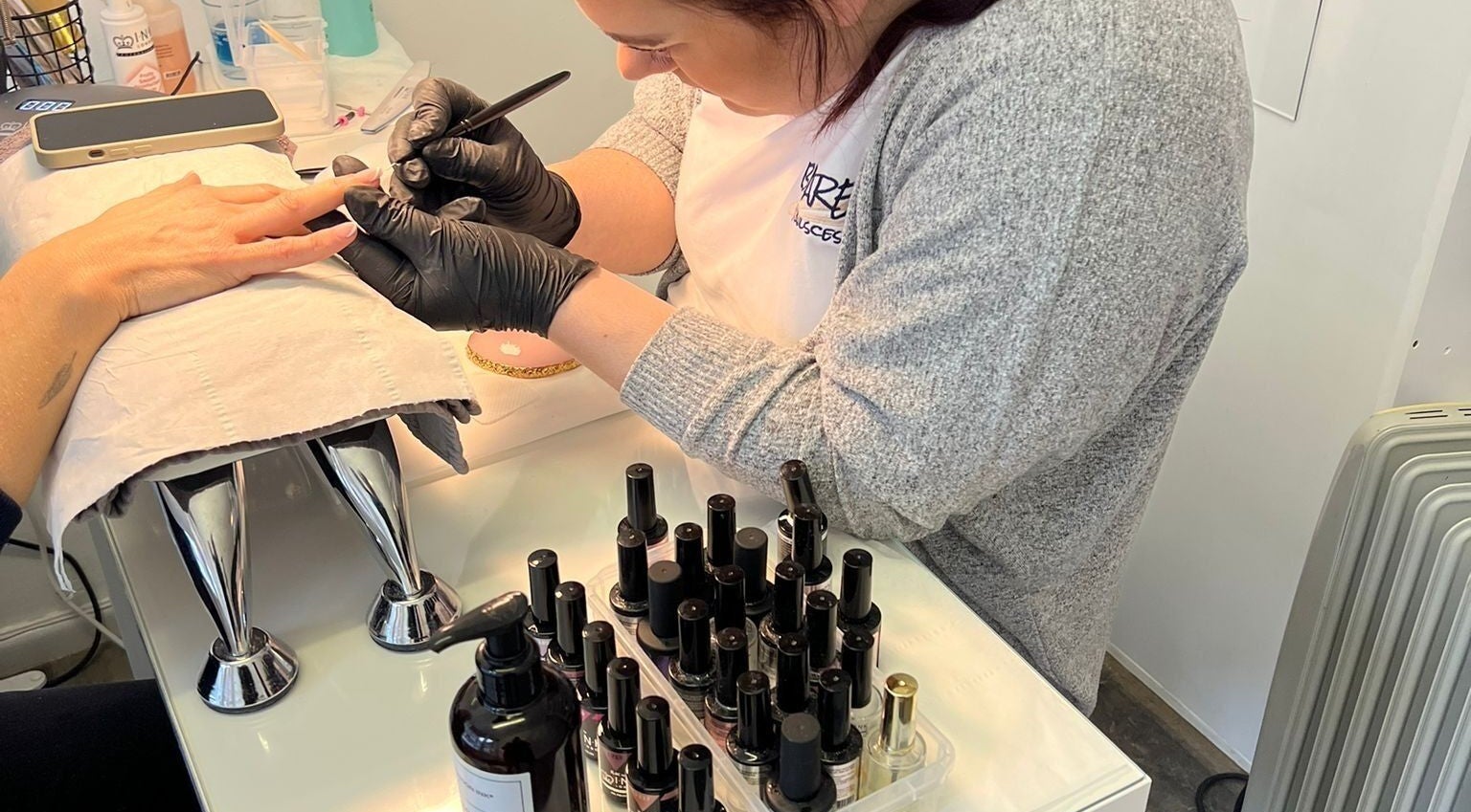 Professional nail artist at Bare Nailscessity @ Hidden Beauty, East Cowes, England, GB perfecting a manicure.