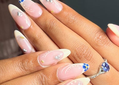 Close-up of nail art with white tips and decorations at Nailvault by Chels, Cape Town, Western Cape, ZA.