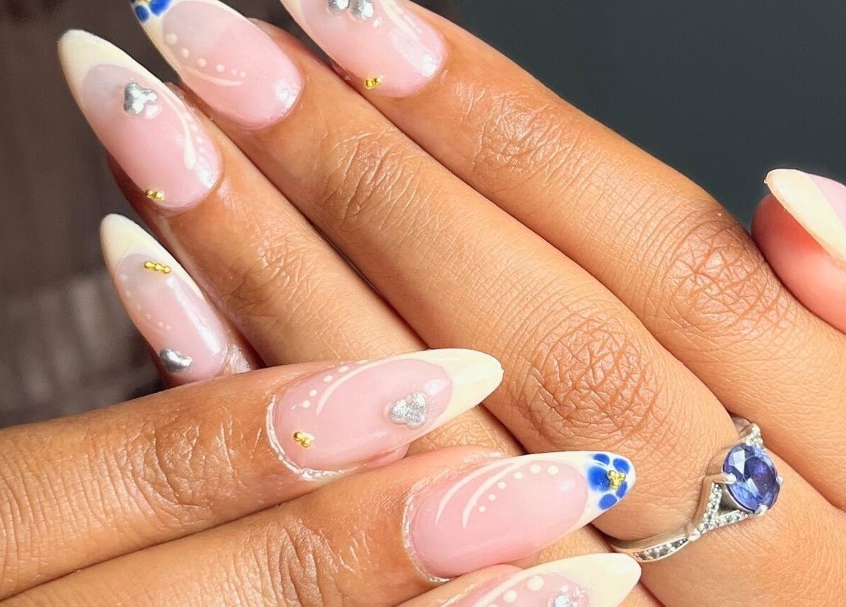 Close-up of nail art with white tips and decorations at Nailvault by Chels, Cape Town, Western Cape, ZA.