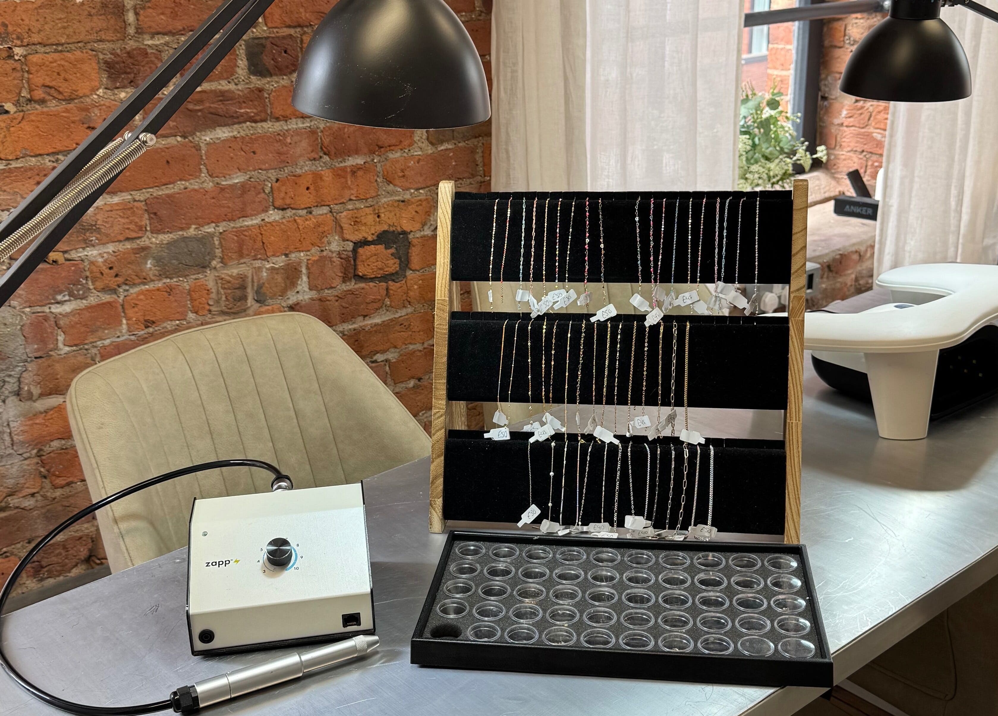 Griff’s Gel Studio in Manchester, England, displays jewelry and equipment in a cozy, brick-themed setting.