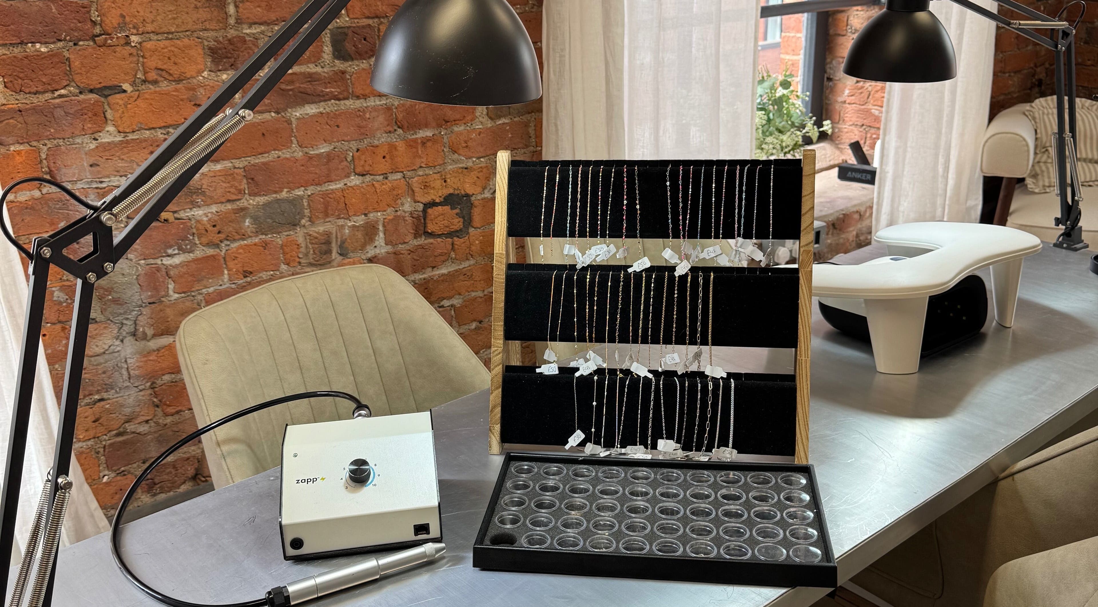 Griff’s Gel Studio in Manchester, England, displays jewelry and equipment in a cozy, brick-themed setting.