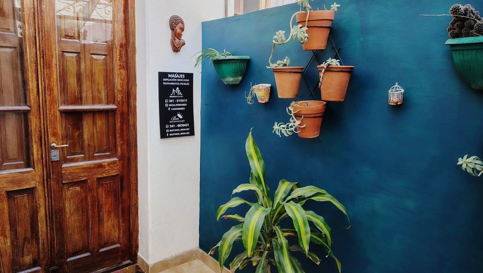 Entrada a Masajes NANDO y Basthian en Rosario con plantas decorativas. Ubicado en Rosario, Santa Fe, AR.