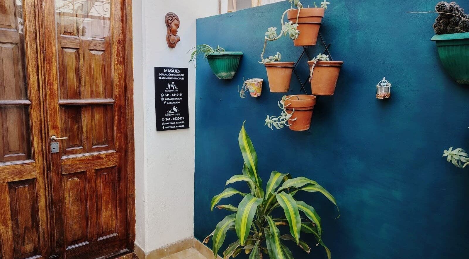Entrada a Masajes NANDO y Basthian en Rosario con plantas decorativas. Ubicado en Rosario, Santa Fe, AR.