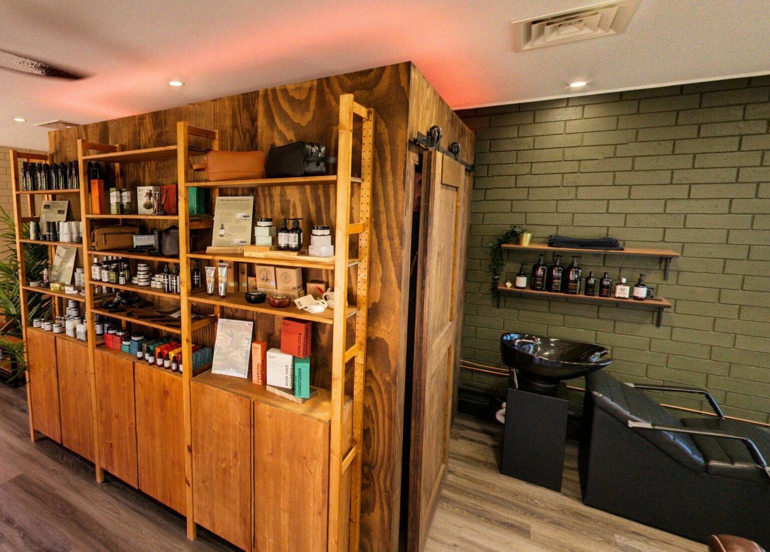 Interior of The Big Beard Cartel Barbershop in Karratha, showcasing products and a stylish seating area.