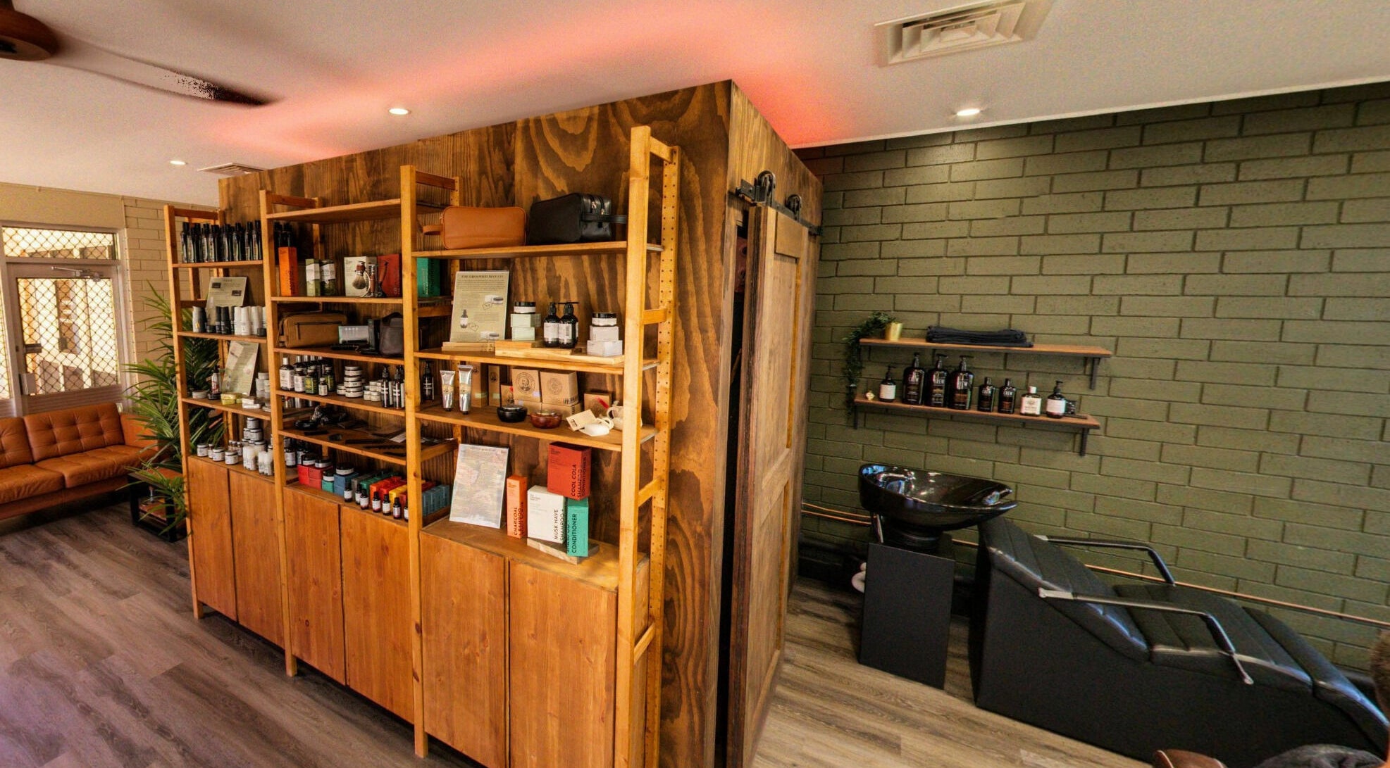 Interior of The Big Beard Cartel Barbershop in Karratha, showcasing products and a stylish seating area.