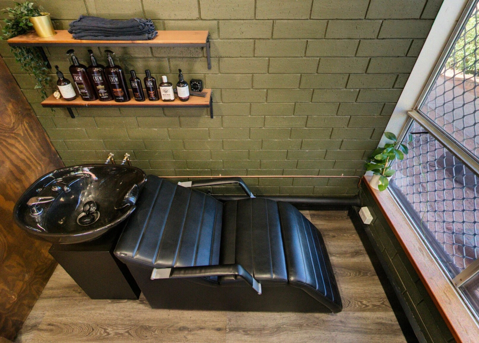Chic wash station at The Big Beard Cartel Barbershop, Karratha, Western Australia, AU, with sleek black chair.