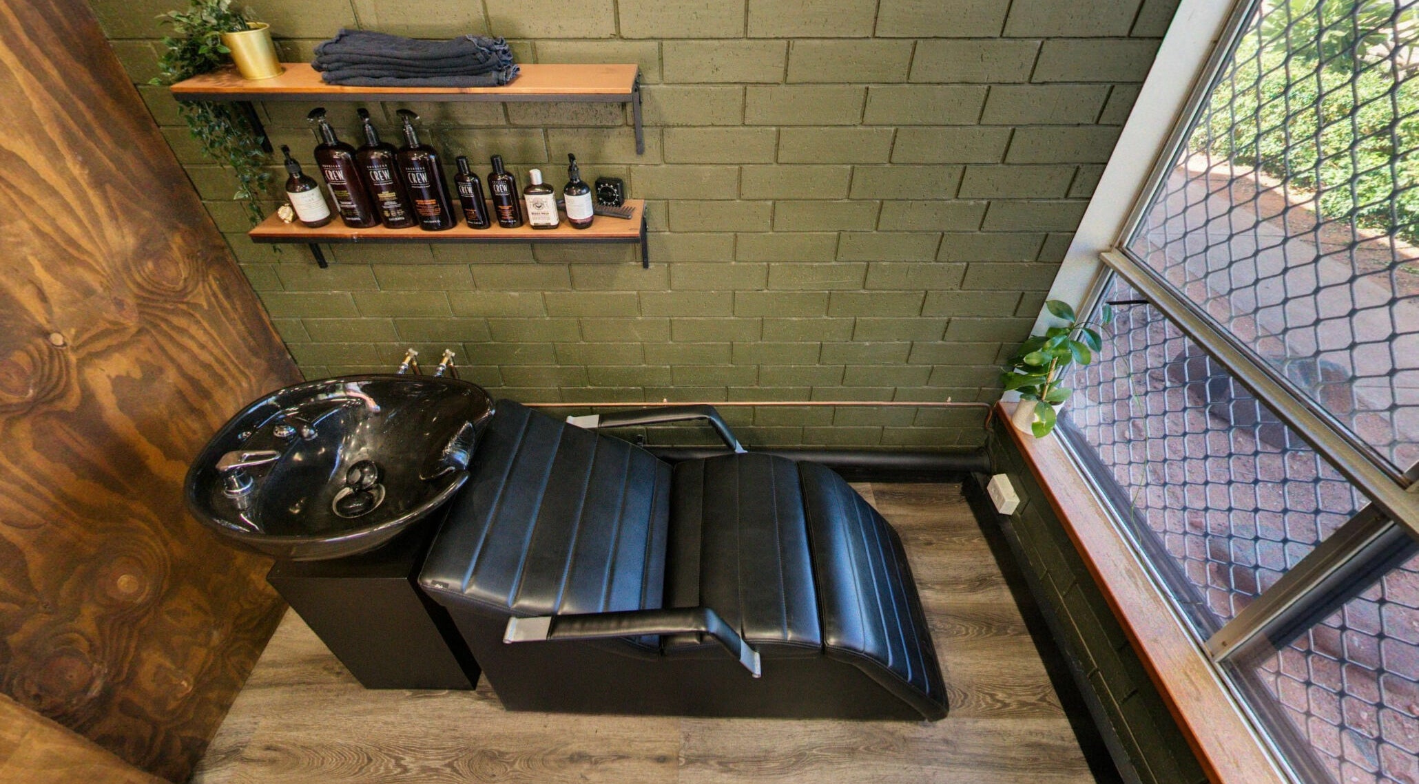 Chic wash station at The Big Beard Cartel Barbershop, Karratha, Western Australia, AU, with sleek black chair.