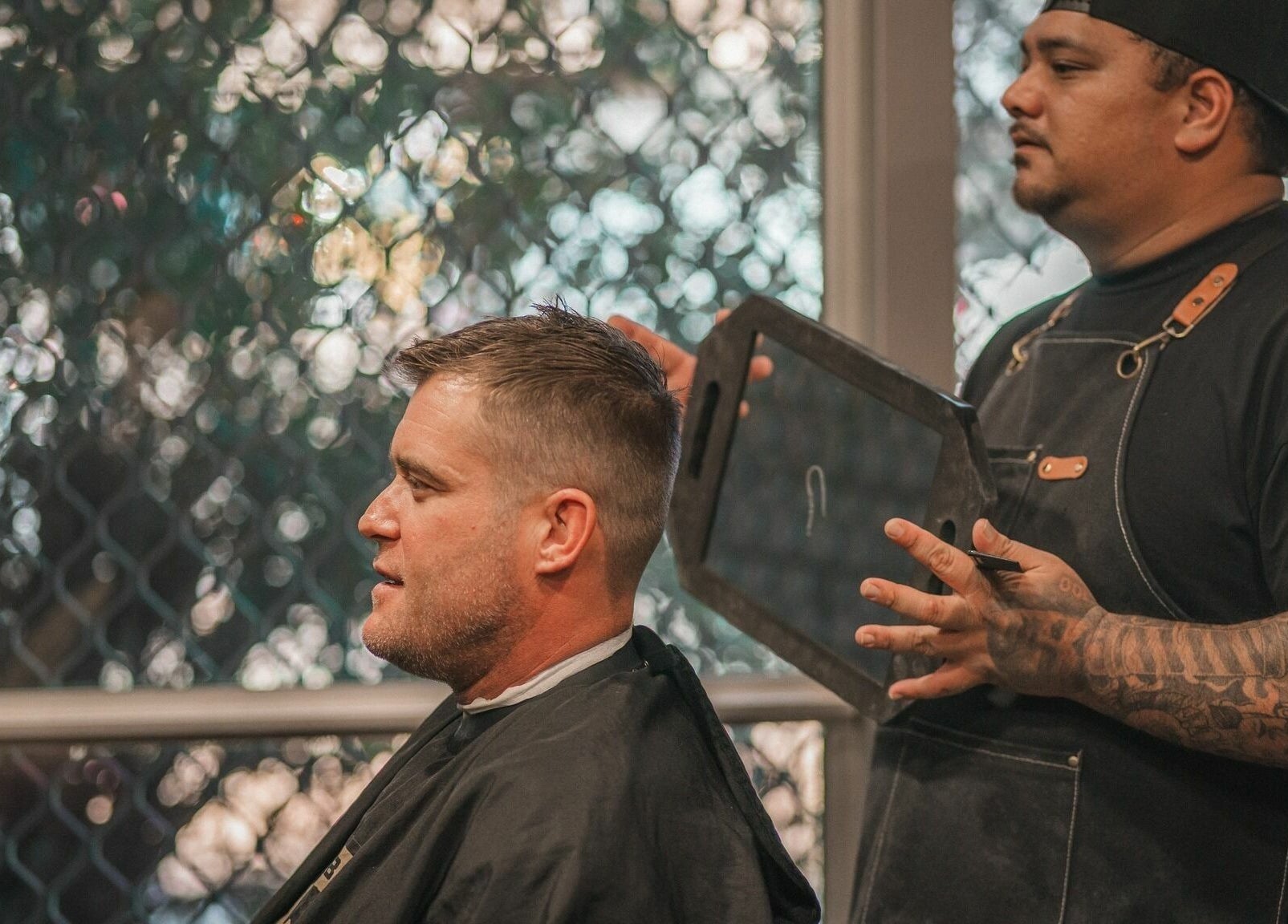 Stylist at The Big Beard Cartel Barbershop in Karratha, Western Australia, AU giving a haircut.