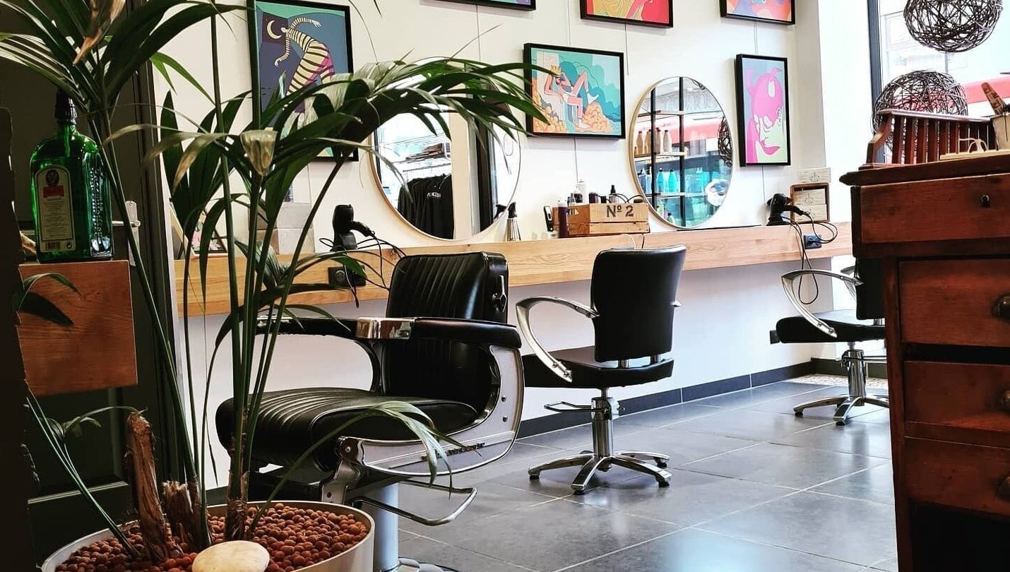 Intérieur moderne du salon de LOFT HAIR à Reims, Grand Est, FR, avec des miroirs et plantes décoratives.