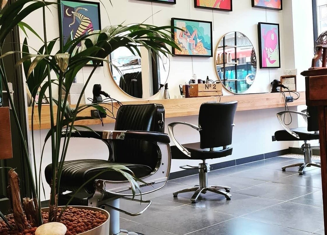 Intérieur moderne du salon de LOFT HAIR à Reims, Grand Est, FR, avec des miroirs et plantes décoratives.