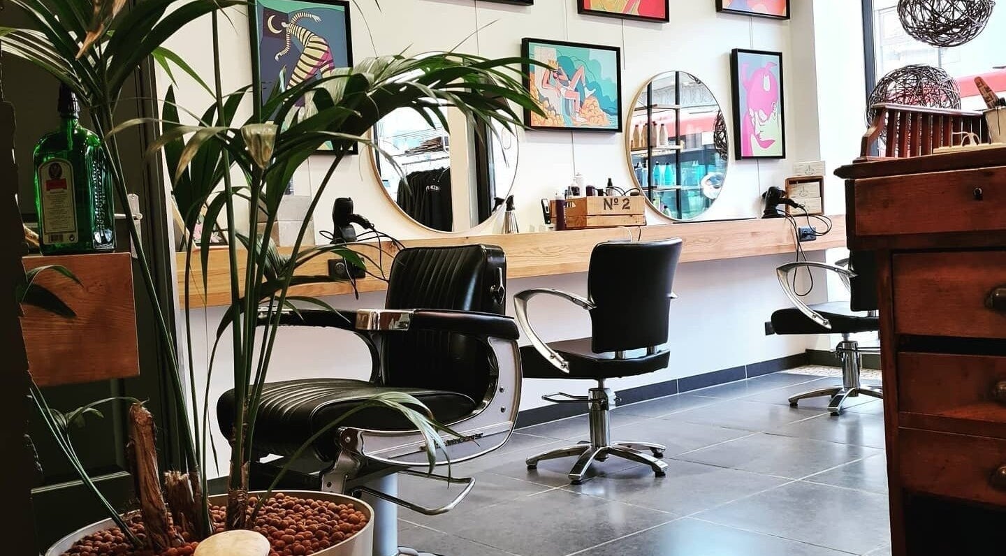 Intérieur moderne du salon de LOFT HAIR à Reims, Grand Est, FR, avec des miroirs et plantes décoratives.
