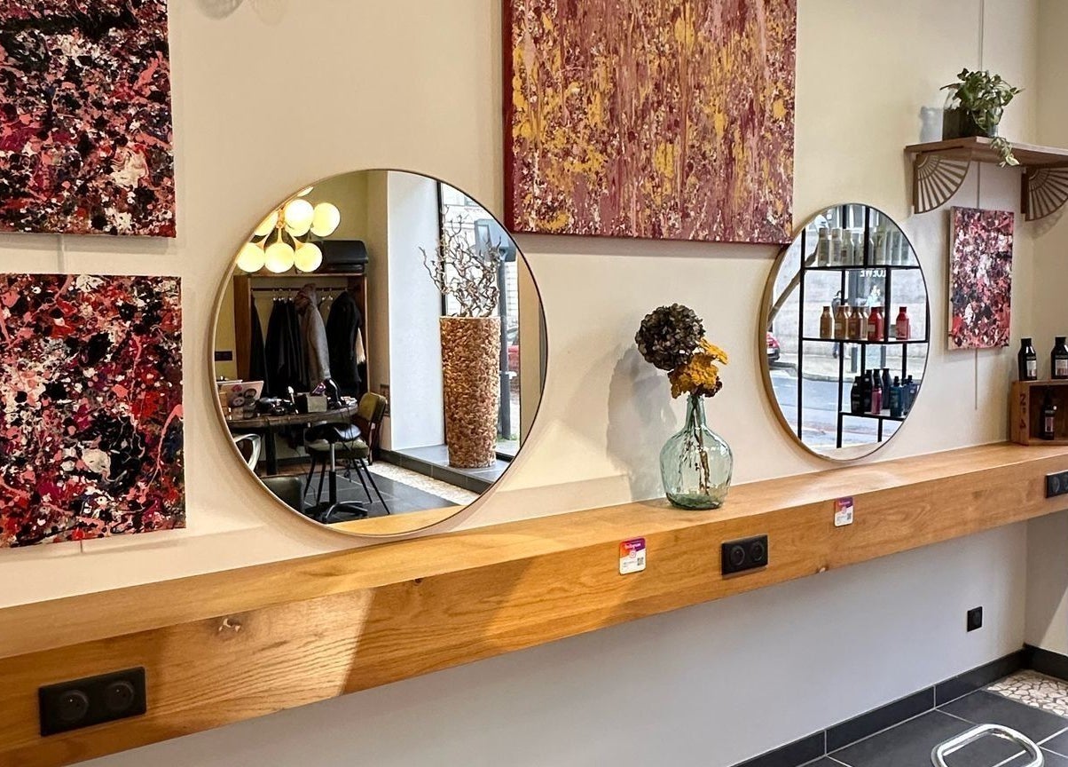 Intérieur élégant de LOFT HAIR, Reims, Grand Est, FR, avec miroirs circulaires et art moderne.