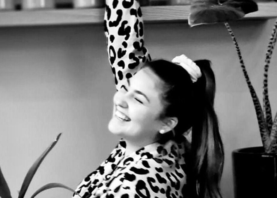 Femme souriante chez LOFT HAIR, Reims, Grand Est, FR, entourée de plantes décoratives.