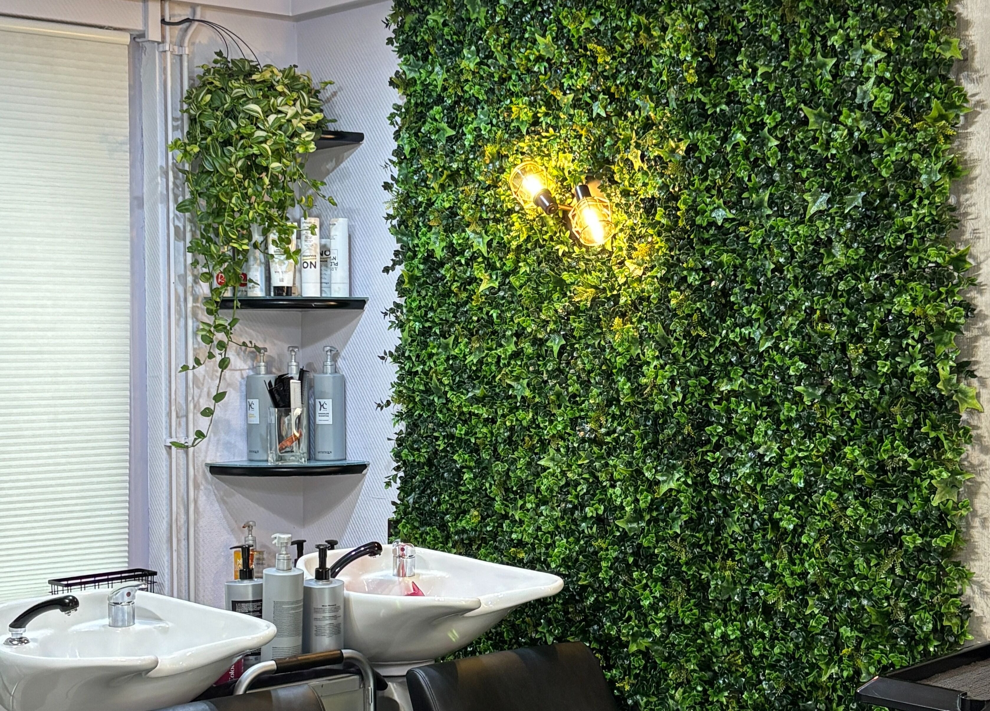 Relaxing salon space at Anima Beauty, Amsterdam, Noord-Holland, NL, with lush greenery and shampoo station.