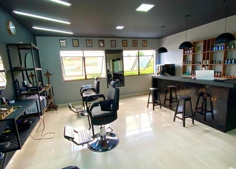 Interior moderno da LS Barbearia em Bahia, Bahia, BR, com cadeiras de barbeiro e balcão estiloso.