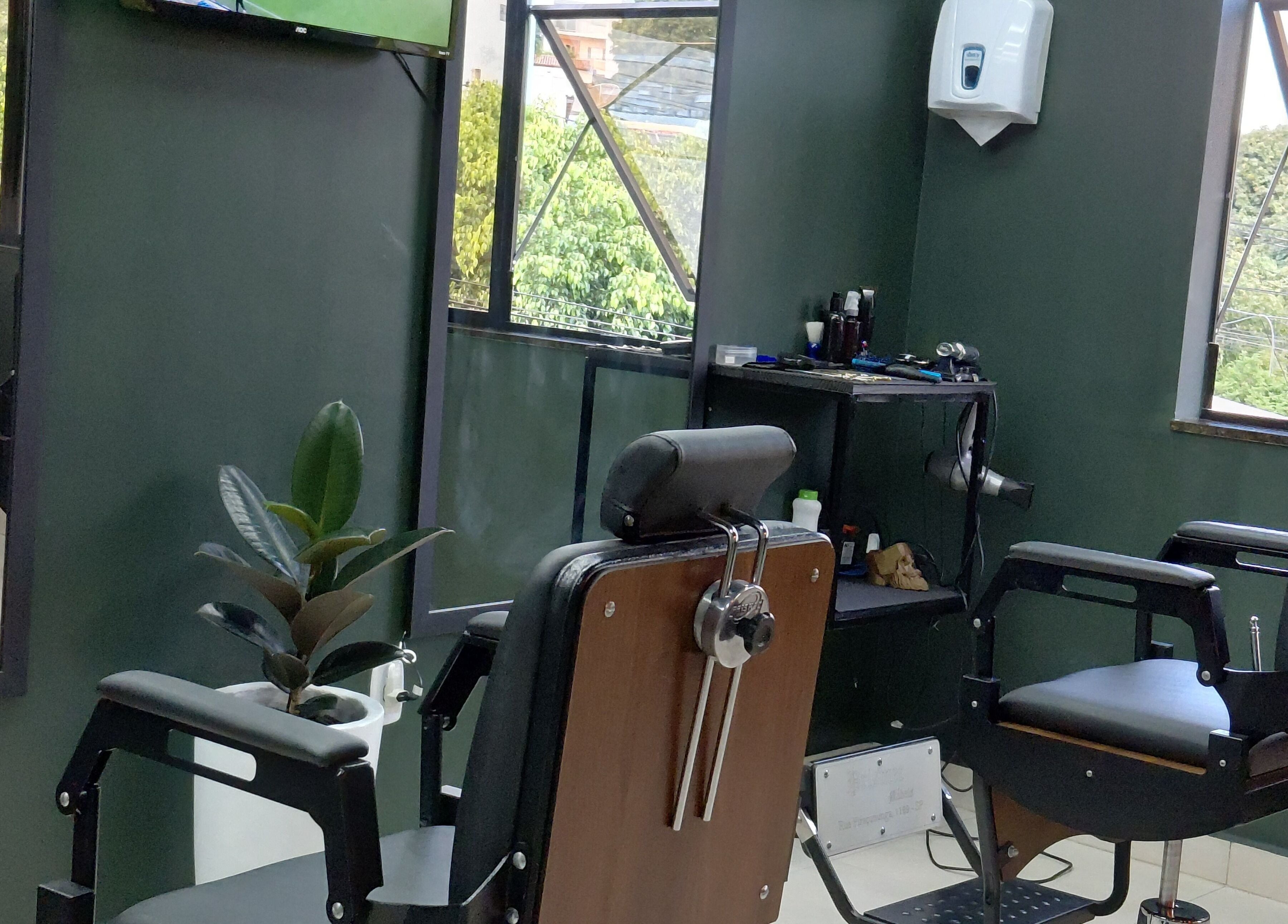 Interior moderno e elegante da LS Barbearia em Bahia, Bahia, BR com cadeiras de barbeiro e decoração verde.