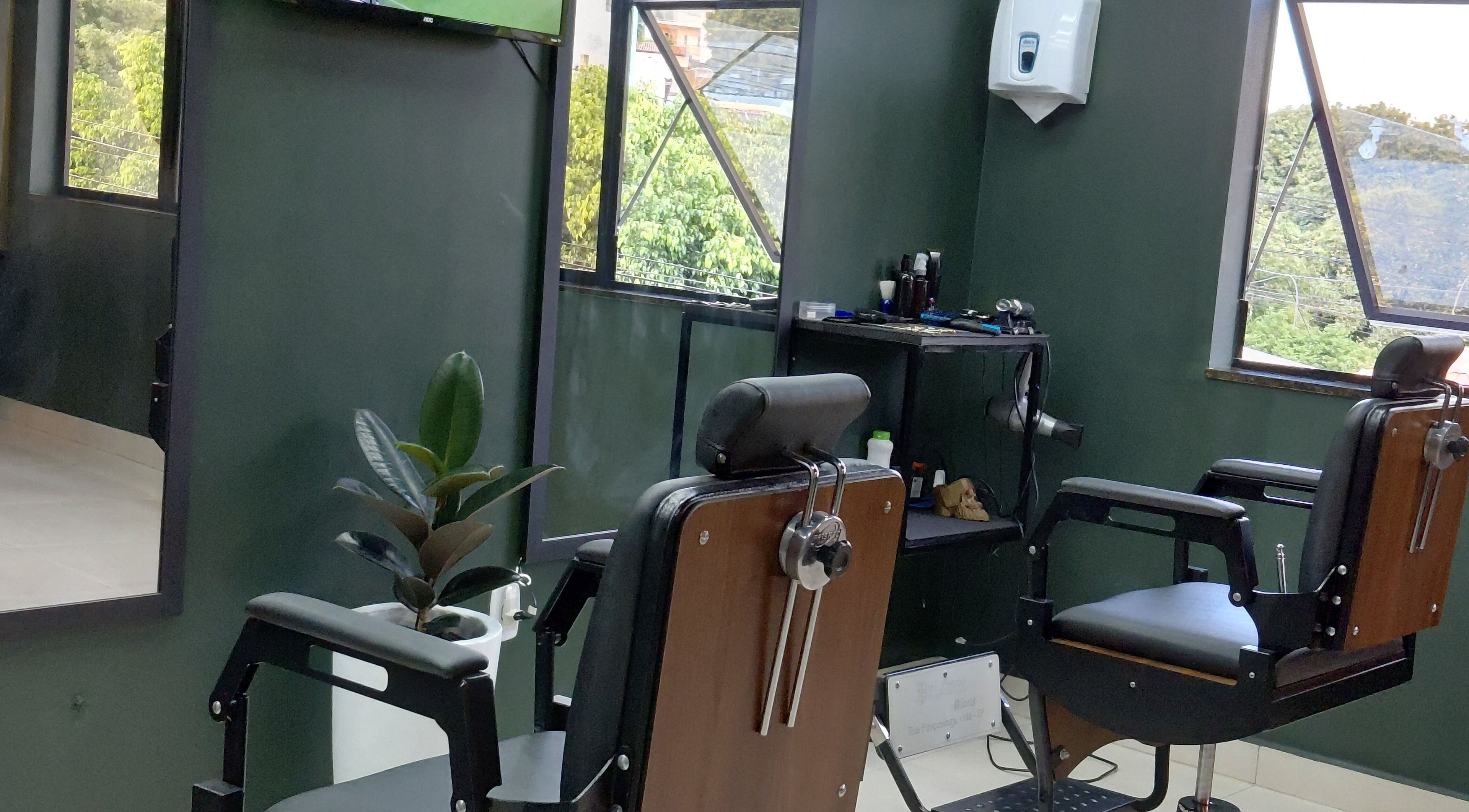 Interior moderno e elegante da LS Barbearia em Bahia, Bahia, BR com cadeiras de barbeiro e decoração verde.