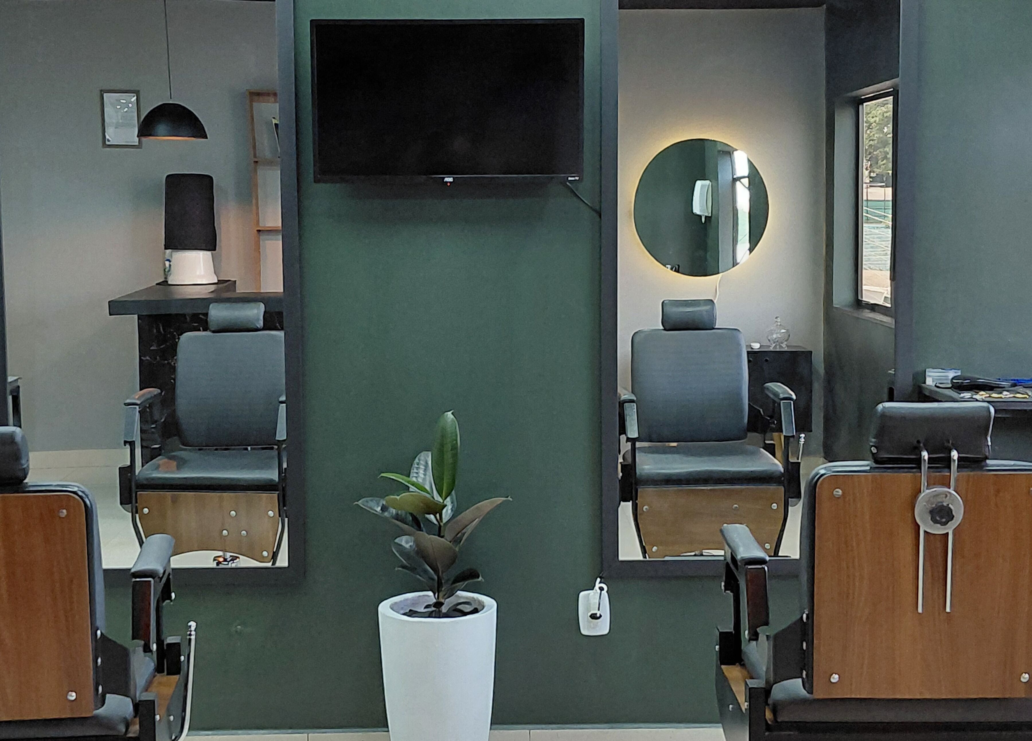 Interior moderno da LS Barbearia em Bahia, Bahia, BR, destacando cadeiras de barbearia e espelhos iluminados.