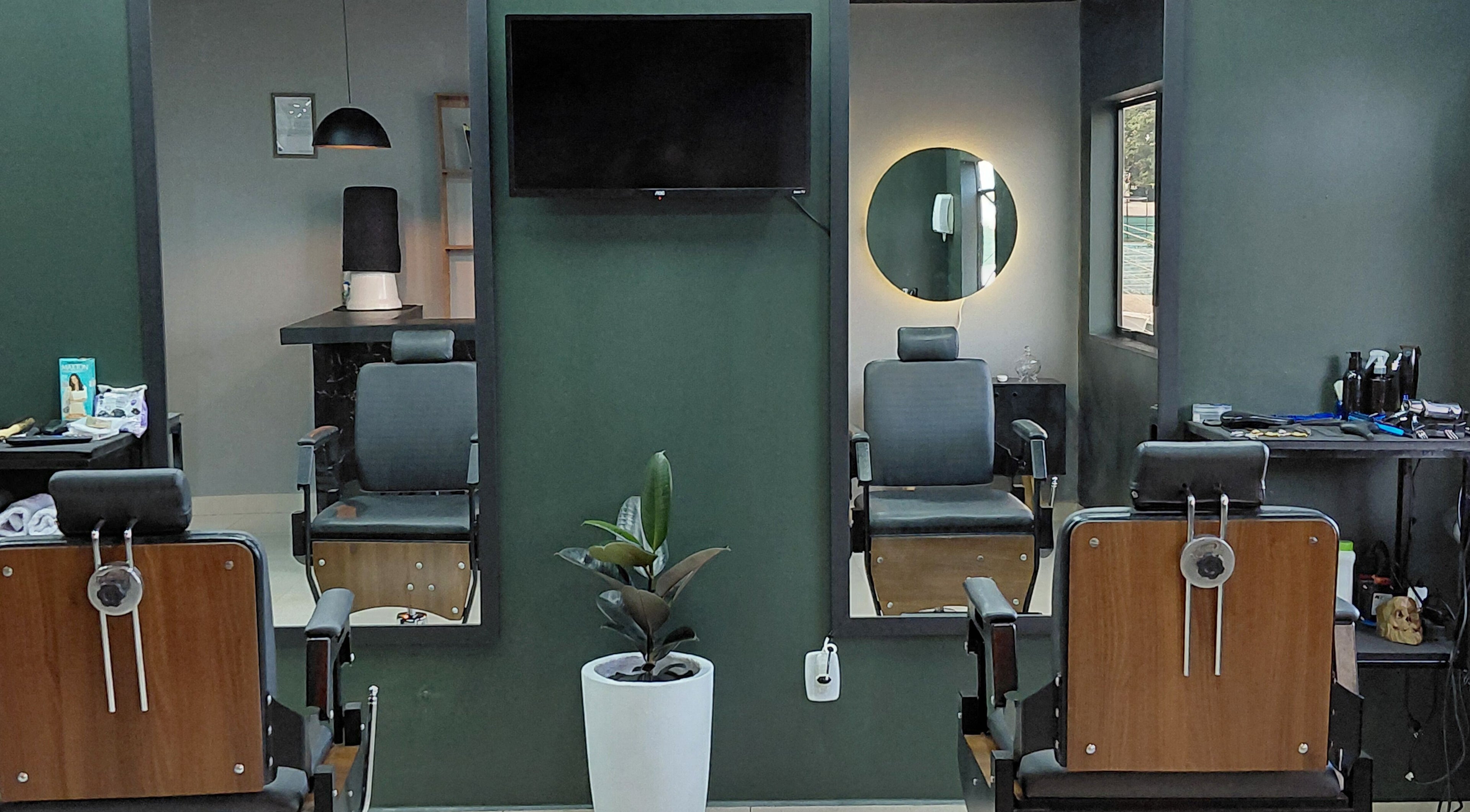 Interior moderno da LS Barbearia em Bahia, Bahia, BR, destacando cadeiras de barbearia e espelhos iluminados.