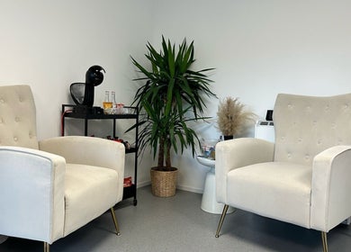 Comfortable seating area at Millzbeauty, High Wycombe, England, GB with plush chairs and greenery.