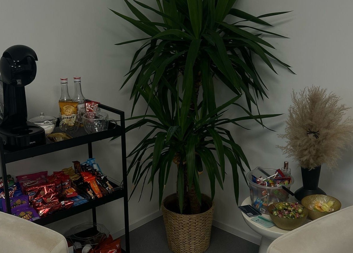 Relaxing snack and coffee corner at Millzbeauty in High Wycombe, England, GB with a lush green plant.