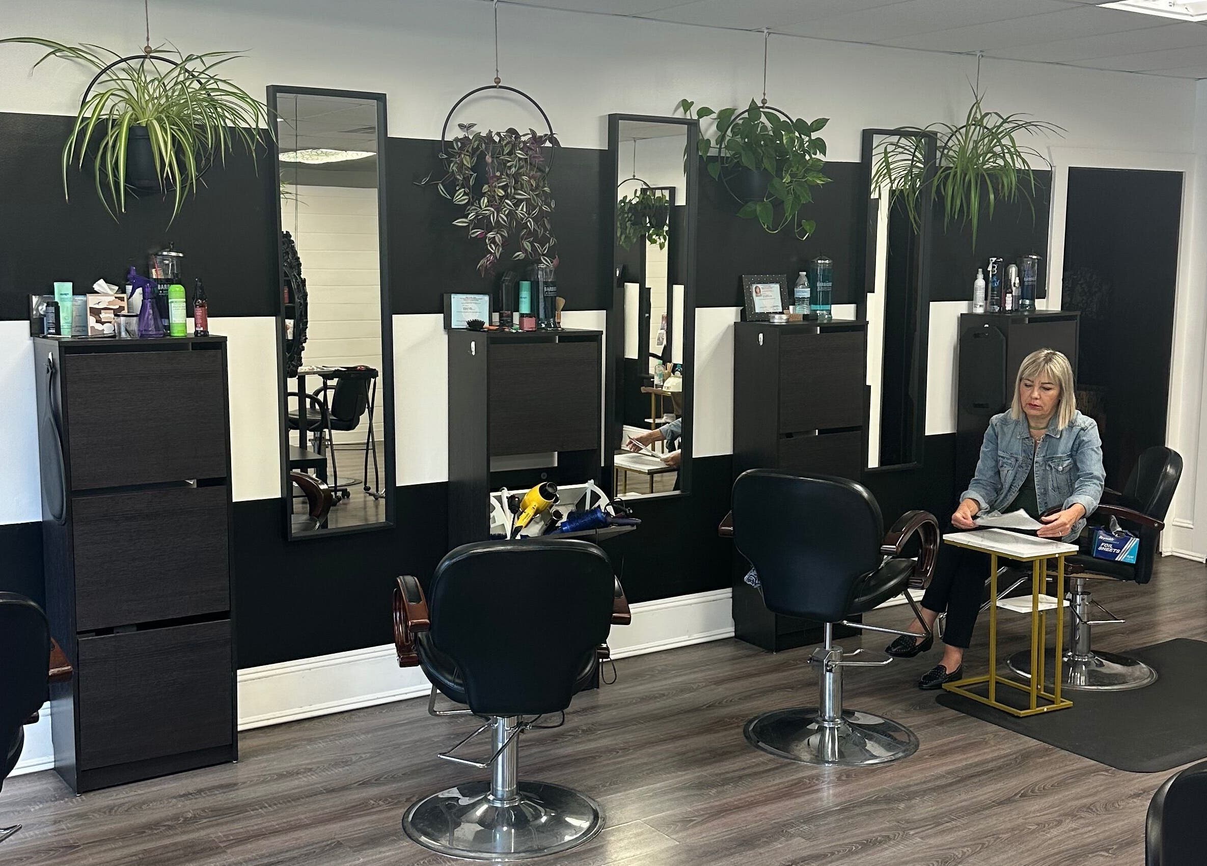 Modern salon interior at Salon Soiree, Denville, New Jersey, US, featuring stylish black chairs and wall mirrors.